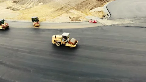 Aerial view of the yellow road rollers that lay the asphalt of the test ground Vídeo Stock 166597250