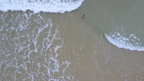 Aerial view of young boy heading into sea for a swim Stock Footage 145178977