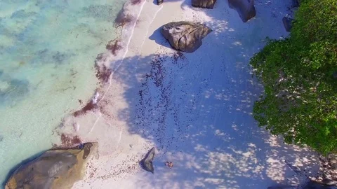 Aerial View Of A Young Couple Watching Quadcopter Drone Flying Up, Seychelles Stock Footage