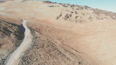 Aerial view - A young guy goes hiking to a volcano through the desert, Teide Stock Footage 111247785