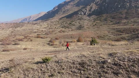 Aerial View Young hiker walking on a mountain path on a sunny day Stock Footage 330662853