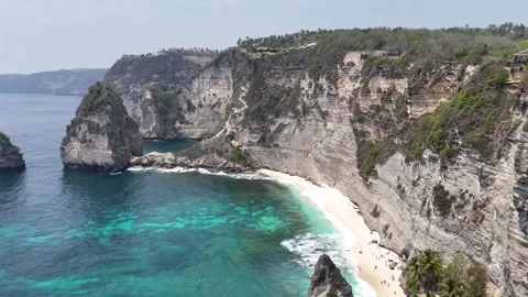 Aerial view of young lady on the cliff of Diamond Beach, Nusa Penida, Bali. Stock Footage 319924528