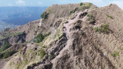 Aerial view of young lady is walking on top of Batur volcano in Bali, Indonesia Stock Footage 316194053