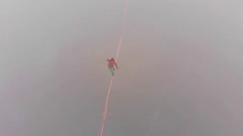 Aerial view of a young man balancing on a weakly stretched sling at a high Video stock 151229629
