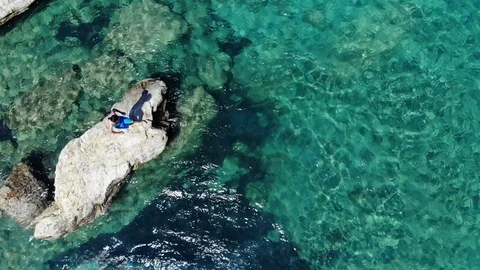 Aerial view young man jump in water from rock, Crete, Greece Stock Footage 101756609