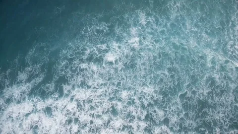 Aerial view of young man stand up paddle boarding on blue ocean waves Video stock 76602803