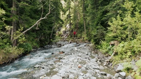 Aerial view; young man walking on suspension bridge Video stock 118748879