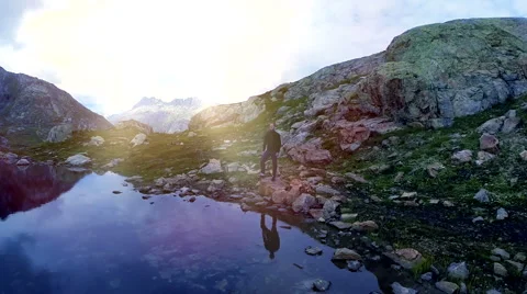 Aerial view of young single man standing alone in mountain lake landscape Stock Footage 42276789