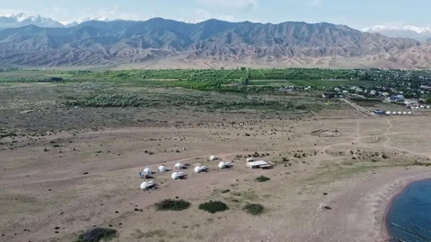 Aerial view of yurt camp by mountains near Issyk Kul lake in Tosor, Kyrgyzstan Stock Footage 345410656