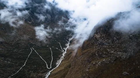 Aerial view on zig zag mountainous road through the valley Stock Photos