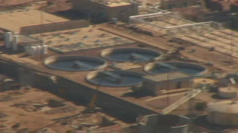 Aerial view zoom in and out of water tanks at treatment plant Stock Footage