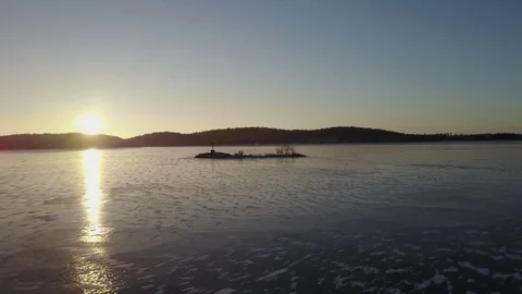 Aerial view:Flying on sunrays over ice floe and island with orthodox cross on it Stock Footage 71252172