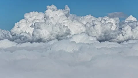 Aerial views of massive fluffy white cumulus clouds in blue sky above Stockbeeldmateriaal 332755146