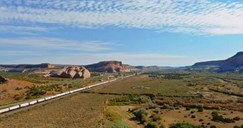 Aerial views over train going through dry lands in a desert New Mexico USA Stock Footage 157882742