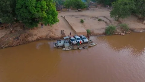 Aerial views showcase a ferry transporting four wheel drive vehicles across a Stock Footage 308394107