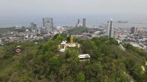 Aerial views of standing big Buddha facing to cityscape and sea in Chonburi Stock Footage