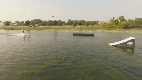Aerial of Wake boarder going off a ramp on a lake Stock Footage 103292586