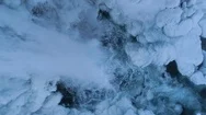 Aerial Of Waterfall From Snow Covered Rocky Cliff In Winter Stock Footage