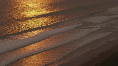 Aerial of waves approaching the coast silently during sunset Stock Footage 79790047