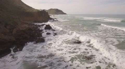 Aerial of waves break along eroding coast Stock Footage 53798622