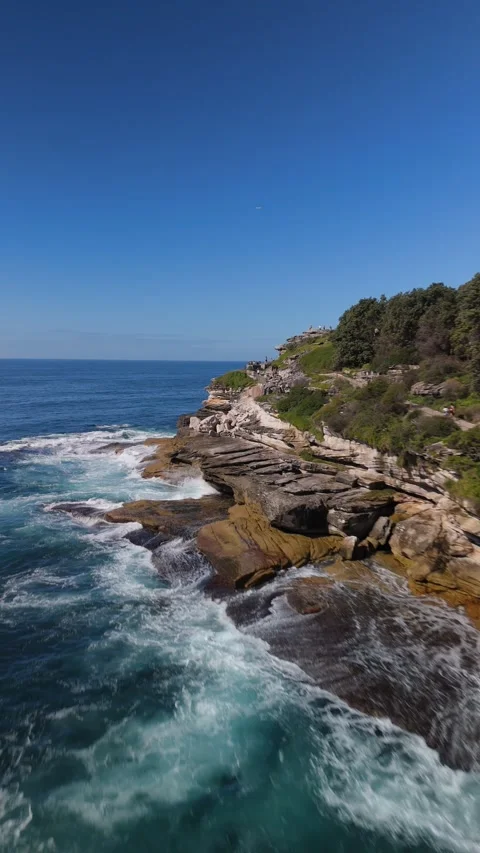 Aerial of Waves Crashing on Rugged Cliffs in Bondi Vídeo Stock 332103684