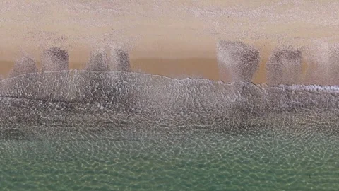 Aerial Waves Rolling Onto Sandy Beach at Golden Sunrise Light Stock Footage 325292100