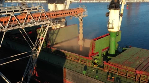 Aerial of wheat loading to bulker ship cargo hold at sea grain elevator in sea Stock Footage 247061782