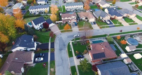 Aerial of a white car driving in Suburban Neighborhood Stock Footage