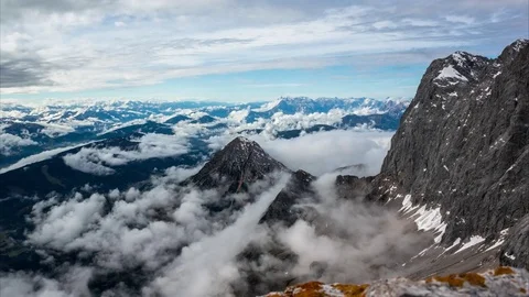 Aerial of white clouds rolling over the rocky mountains Stock Footage 77814933