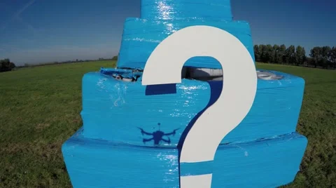 Aerial of white question mark on small bright blue structure drone hoovers 4k Stock Footage 68912285