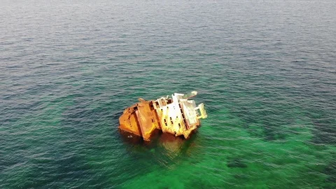 Aerial white sunken ship with rust stands in shallow sea Video stock 103183115