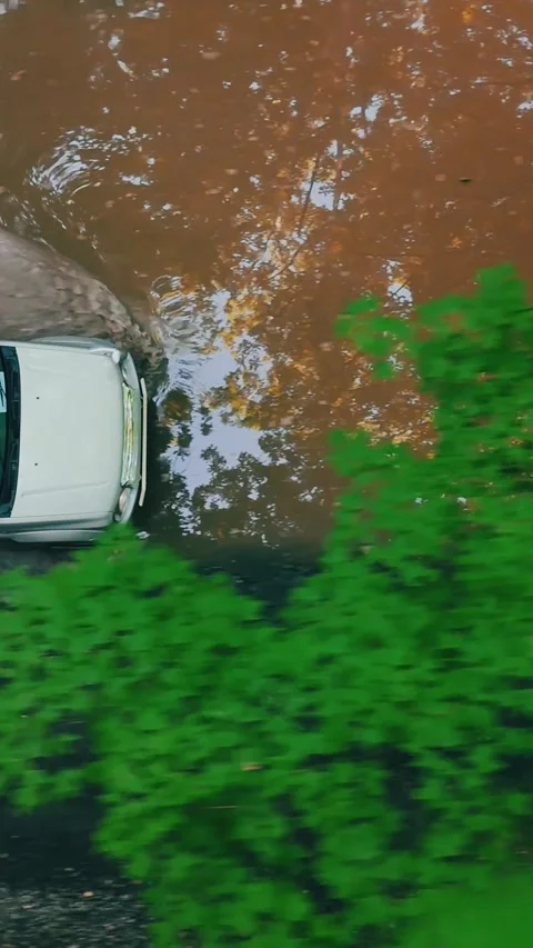Aerial of a white SUV driving through muddy water on rugged terrain... Vídeo Stock 344332633