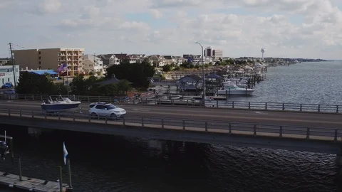 Aerial of white SUV pulling blue white boat over bridge Wrightsville Beach, NC Stock Footage 128381357