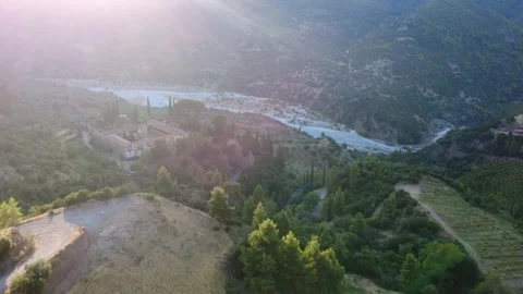 Aerial wide angle of a Byzantine monastery and mountain vineyard at sunset Stock Footage 343962181