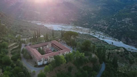 Aerial wide angle of Byzantine monastery castle by river at sunset Stock Footage 343963092