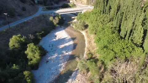 Aerial wide angle of a car crossing a bridge over a rocky river bend Stock Footage 343961742