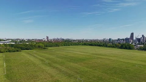 Aerial Wide-Angle Drone Flyover of London Skyline and Football Fields Stock Footage 309761957