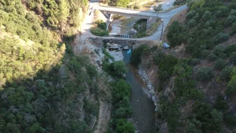 Aerial wide angle of a forest river valley with a distant bridge Stock Footage 343962026