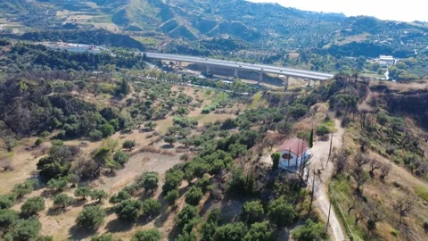 Aerial wide angle panoramic view of a chapel and distant highway bridge Stock Footage 344105169