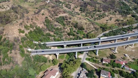 Aerial wide angle push-out view of highway bridge to mountain tunnel Stock Footage 343960880