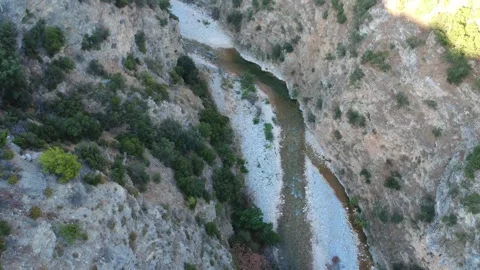 Aerial wide angle of a river flowing through a rocky canyon valley Stock Footage 343961807
