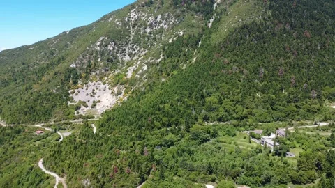 Aerial wide angle shot of cliffside monastery and mountain wilderness Stock Footage 343947390