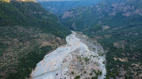 Aerial wide angle shot of a mountain valley river and sunlit peak Stock Footage 343961474