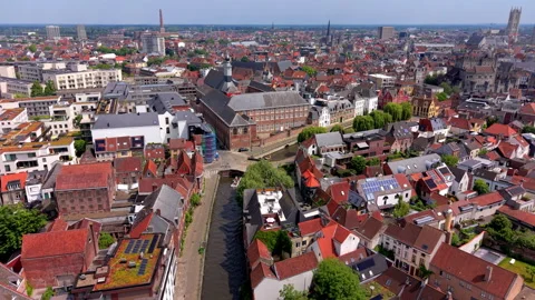 Aerial wide angle shot over a dense European city center with a narrow river Stock Footage 338416554