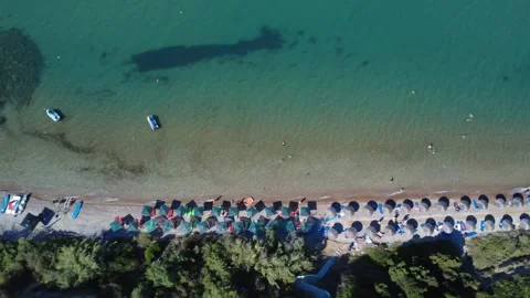 Aerial wide angle shot over a crowded beach with umbrellas and trees. Stock Footage 343939843