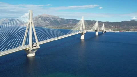 Aerial wide angle shot of Rio-Antirrio Bridge with mountains and sea Stock Footage 338103847
