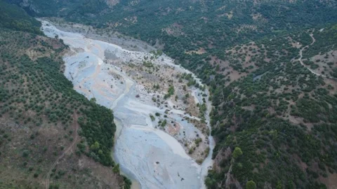 Aerial wide angle shot of a rushing river flowing from a mountain gorge Stock Footage 343961690