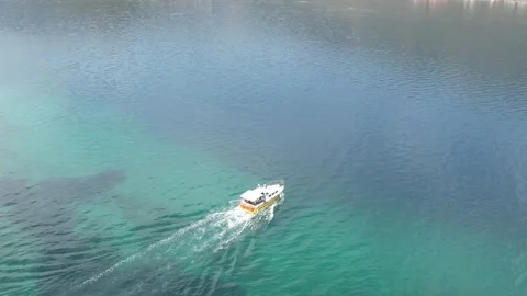 Aerial wide angle view of boat above crystal clear turquoise reef sea Stock Footage 343944086