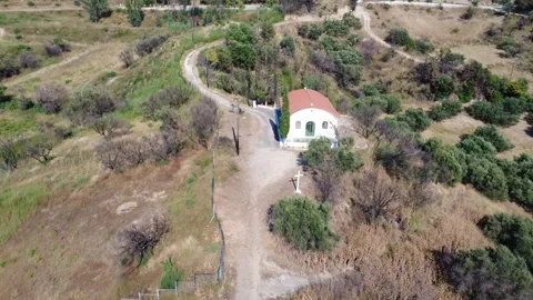 Aerial wide angle view of a hilltop chapel with a cliff side cross Stock Footage 344105212