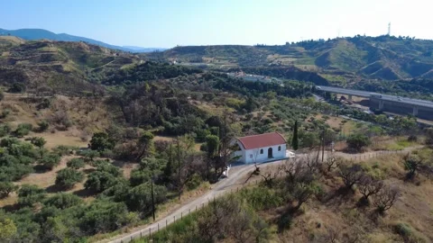 Aerial wide angle view of an isolated white chapel by a dirt path Stock Footage 344105158